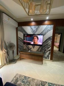 a flat screen tv on a wall in a room at شقه حديثة مكيفه بالكامل فرش مودرن حديث بكومبوند جاردينيا سيتي in Cairo