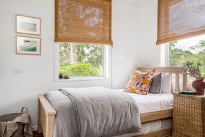 1 dormitorio con cama y ventana en A Perfect Stay - Mullum River House, en Mullumbimby