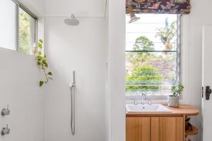 baño con lavabo y ventana en A Perfect Stay - Mullum River House, en Mullumbimby