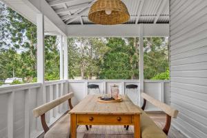 porche con mesa y sillas de madera en A Perfect Stay - Mullum River House, en Mullumbimby