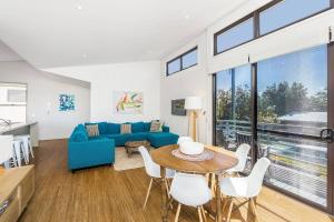 a living room with a blue couch and a table at A Perfect Stay - Sandy Feet in Lennox Head