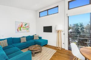 a living room with a blue couch and a table at A Perfect Stay - Sandy Feet in Lennox Head