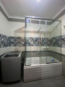 a shower with a glass enclosure in a bathroom at شقه حديثة مكيفه بالكامل فرش مودرن حديث بكومبوند جاردينيا سيتي in Cairo