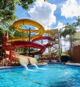 a water slide in a pool at a resort at Flat Caldas Novas - Golden Dolphin Express in Caldas Novas