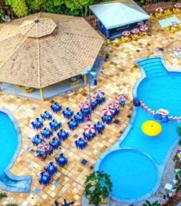 an overhead view of a pool with chairs and an umbrella at Flat Caldas Novas - Golden Dolphin Express in Caldas Novas