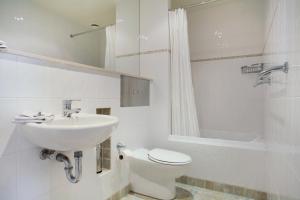 a white bathroom with a sink and a toilet at Stockyards 3 - Jindabyne Luxury Townhouse in Jindabyne