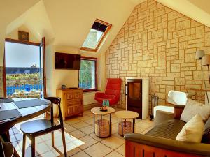 uma sala de estar com uma parede de pedra em Maison Crozon, 3 pièces, 4 personnes - FR-1-370-27 em Crozon