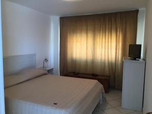 a bedroom with a bed and a television and a window at Sciacca B&B natoli in Sciacca +19 photos