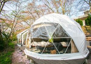 a greenhouse with a couch inside of it at glampark Shikisou Shimane in Izumo