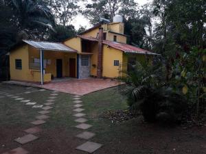 una casa amarilla con una entrada delante de ella en Tranquilidade e conforto na floresta - Rota do Vinho en São Roque