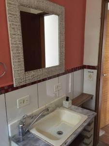 a bathroom with a sink and a mirror at Tranquilidade e conforto na floresta - Rota do Vinho in São Roque