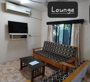uma sala de estar com um sofá e uma televisão em Chands Apartment em Lautoka