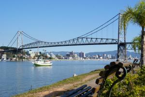 un puente sobre un río con un barco en el agua en Ap aconchegante Floripa, en Florianópolis