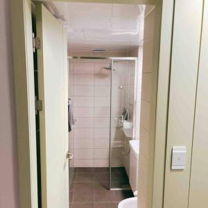 La salle de bains est pourvue d'une douche, de toilettes et d'un lavabo. dans l'établissement Premium Gwangan BnB, à Busan
