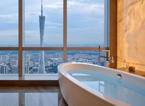 uma banheira na casa de banho com vista para a cidade em Park Hyatt Guangzhou em Guangzhou