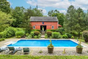 una casa con piscina y un edificio rojo en Hudson Valley Magical Converted Barn & Pool, en Pleasant Valley