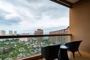 a balcony with chairs and a view of a city at Mangrove Tree Resort World Sanya Bay- Queen Palm Towers in Sanya