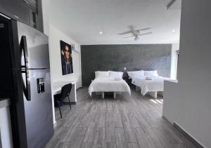sypialnia z 2 łóżkami z białą pościelą w obiekcie LONGVIEW HOME-STUDIOS w mieście Tepic