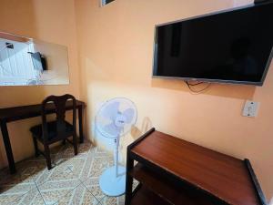 a living room with a fan and a flat screen tv at Hotel Barroco in San José
