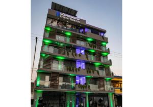 wysoki budynek z zielonymi i fioletowymi światłami w obiekcie LONGVIEW HOME-STUDIOS w mieście Tepic