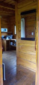 Habitación con pared de madera en una cabaña de madera en Cabaña El Cardenal en Tandil