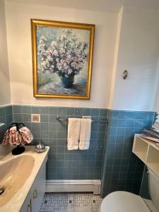 uma casa de banho com uma pintura de um vaso de flores em Welcoming Private Suite with French Touches em Union