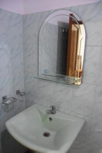 lavabo blanco en el baño con espejo en Maharagama Shehan Hotel en Maharagama