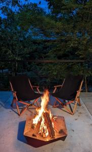 two chairs and a fire pit on a patio at Hakuba Aurora Chalet by Jade Villa in Hakuba