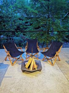 un grupo de tres sillas sentadas en un patio en Hakuba Aurora Chalet by Jade Group, en Hakuba