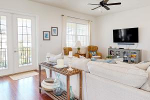 sala de estar con muebles blancos y TV de pantalla plana en Cinnamon Chateau, en Palm Coast