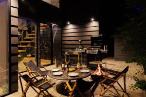 un patio con mesa, sillas y parrilla en Hakuba Aurora Chalet by Jade Group, en Hakuba