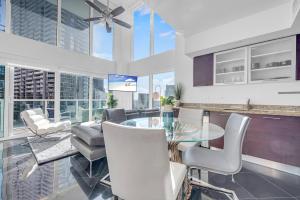 une cuisine et une salle à manger avec une table et des chaises en verre dans l'établissement Iconic 2 BR LOFT Brickell-Stunning views, à Miami