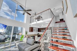 a living room with a staircase and a couch at Iconic 2 BR LOFT Brickell-Stunning views in Miami