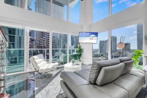 salon z kanapą, krzesłami i oknami w obiekcie Iconic 2 BR LOFT Brickell-Stunning views w Miami