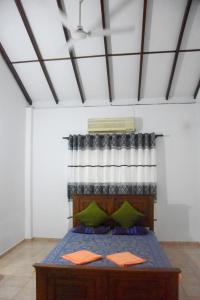 1 dormitorio con 1 cama con almohadas verdes en Maharagama Shehan Hotel en Maharagama