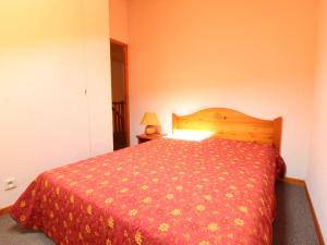a bedroom with a bed with a red comforter at Appartement Aussois, 4 pièces, 8 personnes - FR-1-508-83 in Aussois