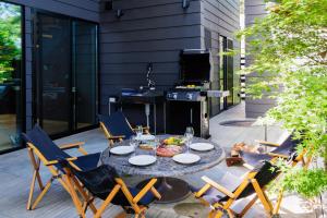 a patio with a table and chairs and a grill at Hakuba Aurora Chalet by Jade Villa in Hakuba