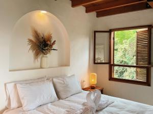 a bedroom with a white bed with a window at Hotel Auen Posada Andina in La Unión