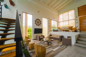 ein Wohnzimmer mit Möbeln und einer Treppe in der Unterkunft Casa privada en Isla Barú 5BR in Barú