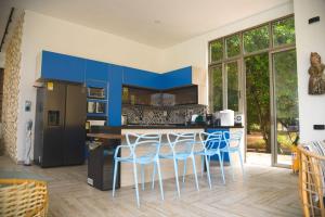 una cocina con armarios azules y una barra con taburetes en Casa privada en Isla Barú 5BR, en Barú