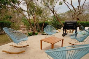 three blue chairs and a table and a piano at Casa privada en Isla Barú 5BR in Baru