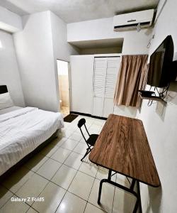 een slaapkamer met een bed en een houten tafel. bij BTX 31 Residence Bintaro in Peladen