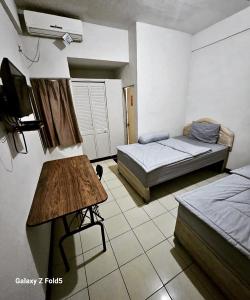 een kamer met 2 bedden en een televisie. bij BTX 31 Residence Bintaro in Peladen