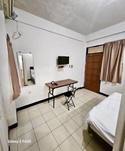 een slaapkamer met een tafel, een bed en een televisie bij BTX 31 Residence Bintaro in Peladen