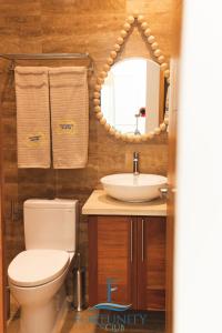 a bathroom with a toilet and a sink and a mirror at Fortunity Club- Playa Dorada, Pto Plata in San Felipe de Puerto Plata