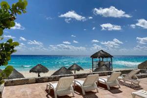 un grupo de sillas y sombrillas en una playa en Condominiums in Solymar, en Cancún