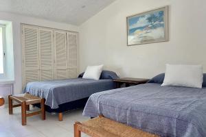 1 dormitorio con 2 camas y ventana en Condominiums in Solymar, en Cancún