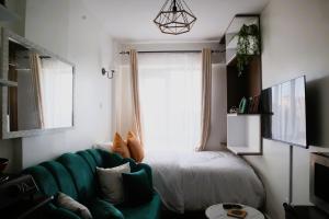 a living room with a green couch and a window at El Hogar II in Kiambu