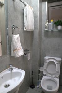 Łazienka z białą toaletą i umywalką w obiekcie El Hogar II w mieście Kiambu
