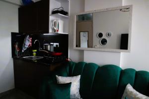 a green couch in a room with a mirror at El Hogar II in Kiambu +12 photos